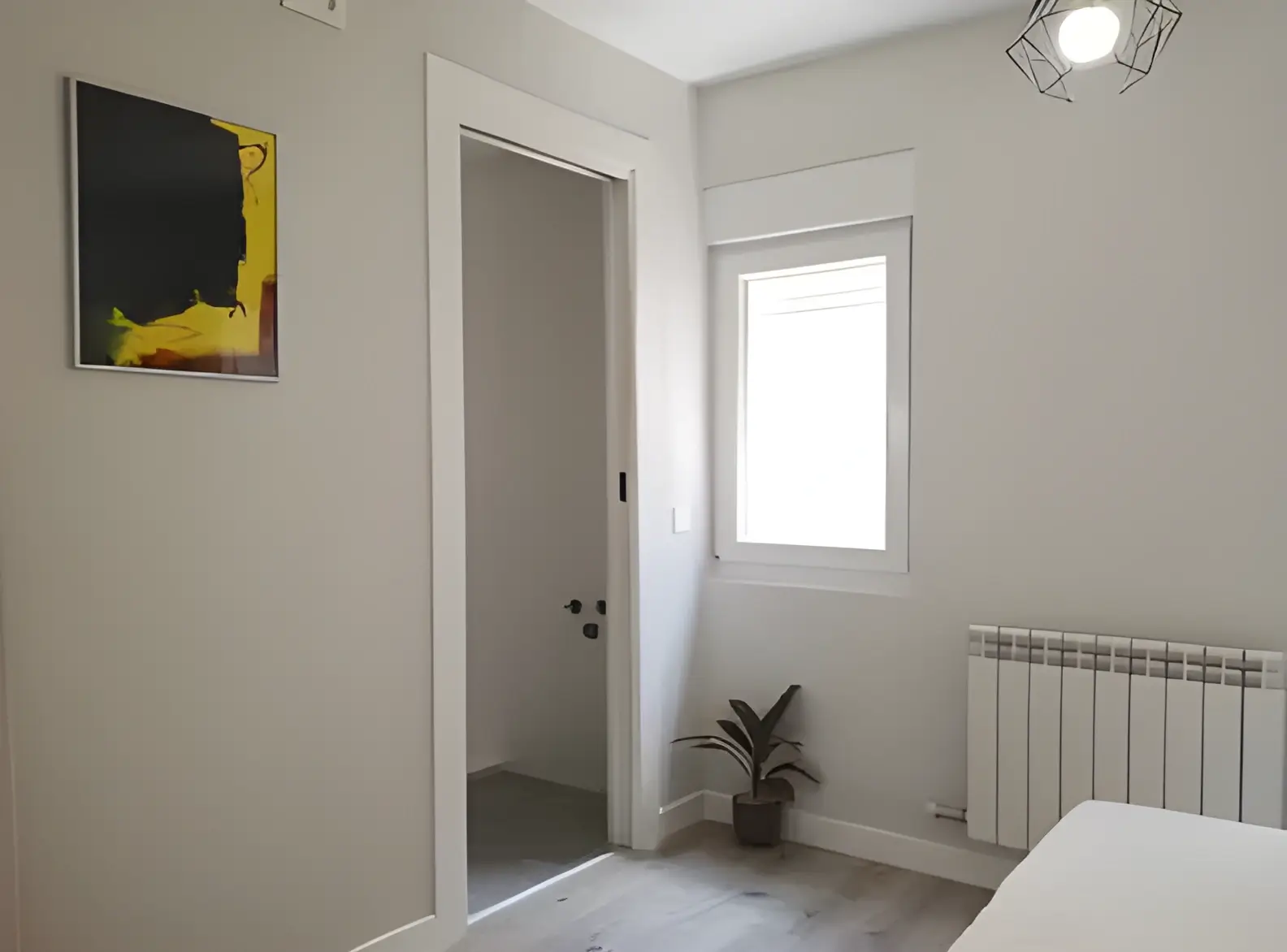 Habitación recién pintada en blanco por Los Pintores Fuenlabrada para comunidad de vecinos