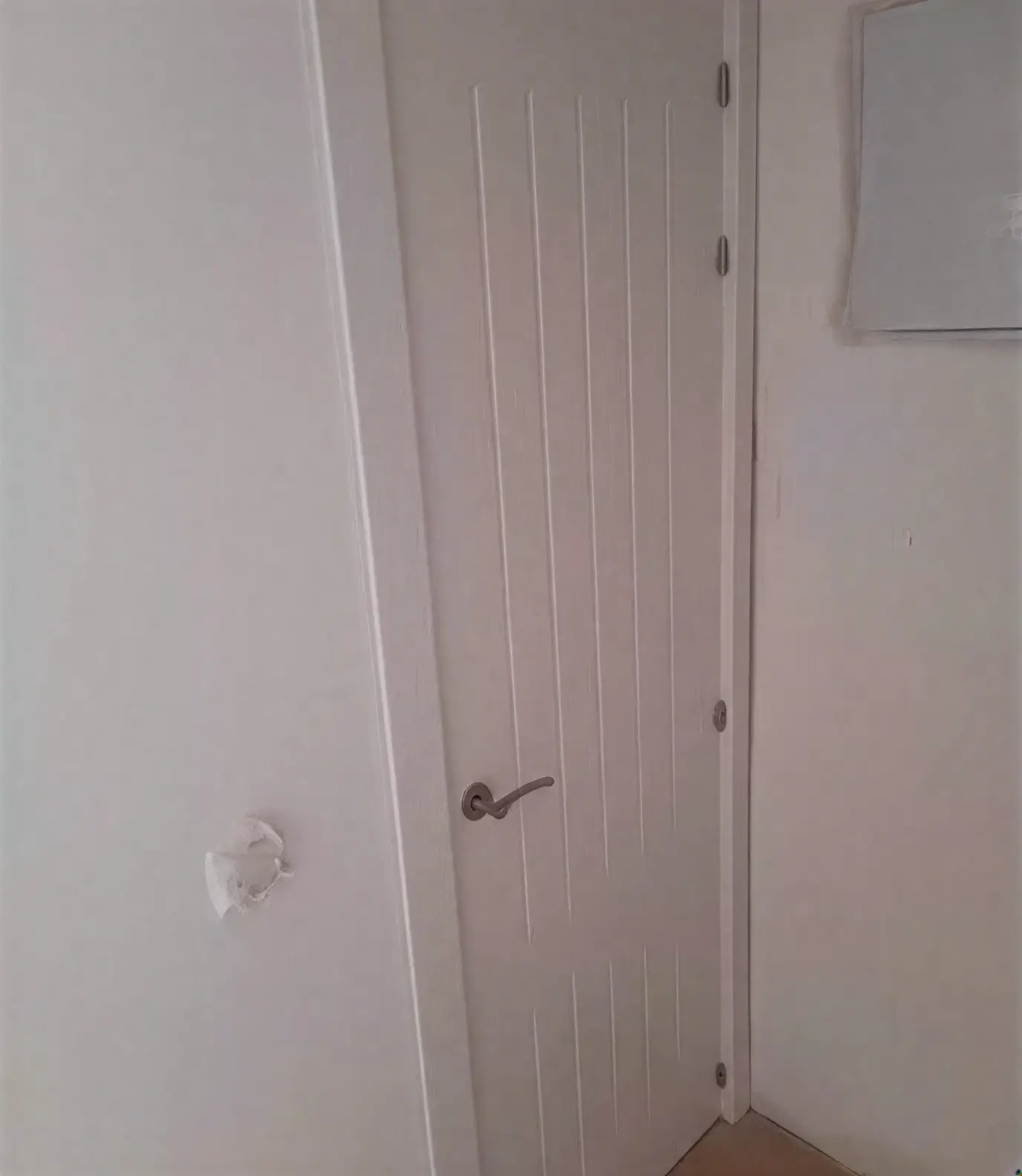 Puerta moderna con ranuras lacada en blanco por pintores profesionales en Fuenlabrada