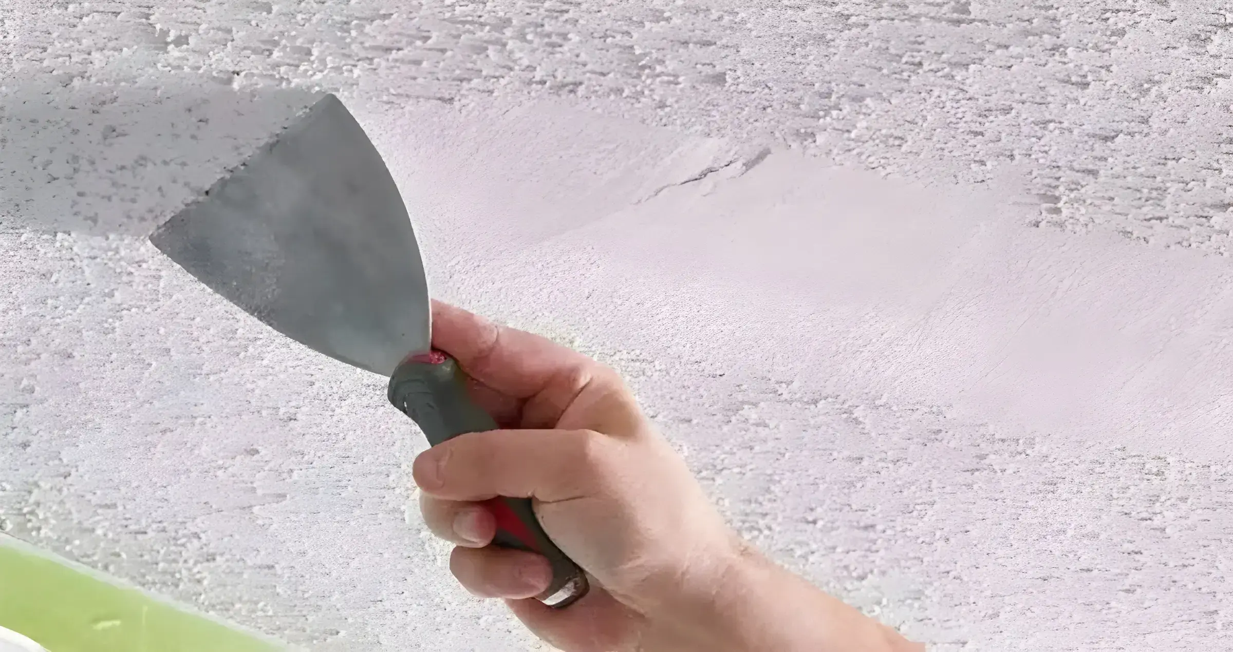 Los Pintores Fuenlabrada eliminando el gotelé con espátula para dejar la pared lisa